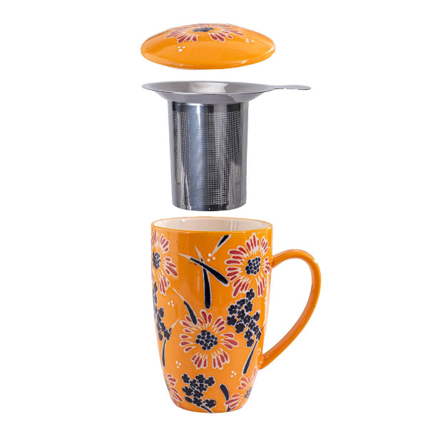 Orange mug with floral design and metal tea infuser on a white background. The Spice & Tea Shoppe