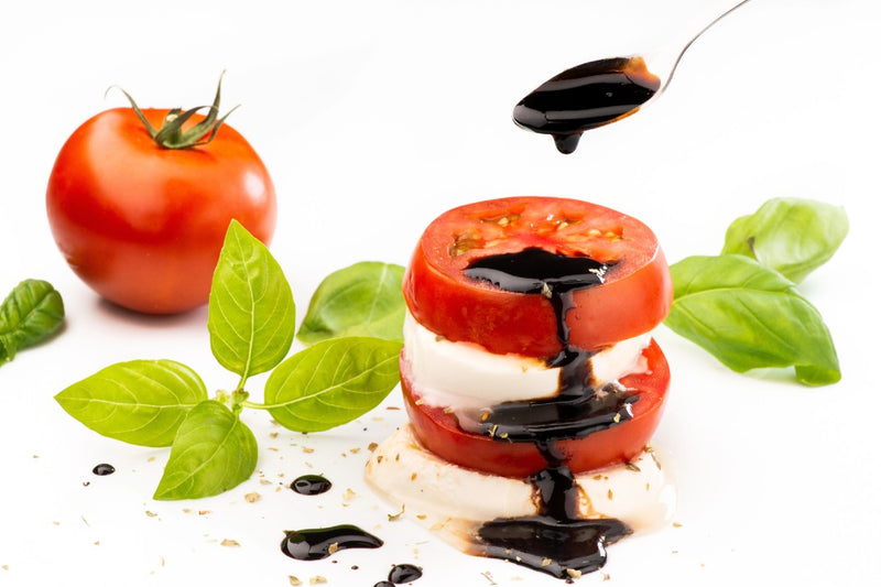 Dark balsamic vinegar drizzled over fresh tomatoes and mozzarella with fresh basil leaves. The Spice and Tea Shoppe