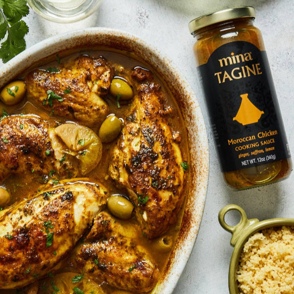 Moroccan chicken tagine with olives and lemon, accompanied by a jar of 'mina Tagine' cooking sauce.  The Spice & Tea Shoppe