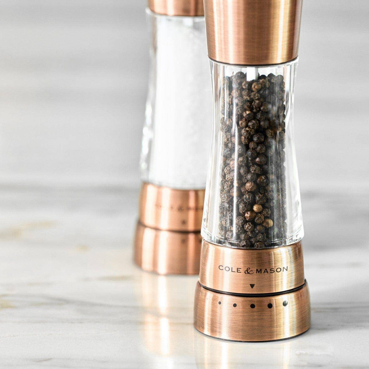 A pair of Cole & Mason Derwent salt and pepper mills in a metallic copper finish.