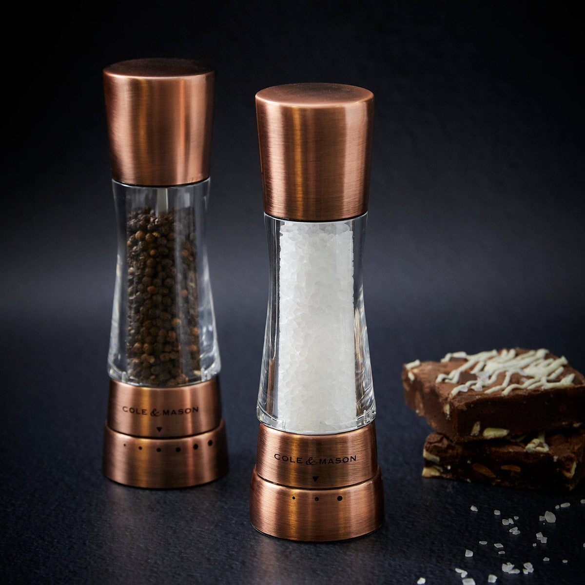 A pair of Cole & Mason Derwent salt and pepper mills in a metallic copper finish.