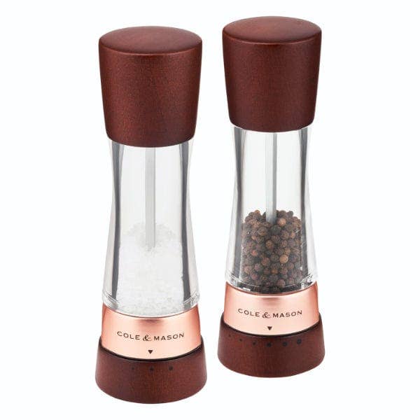 A pair of Cole & Mason Derwent salt and pepper mills featuring dark wood tops and bases with rose gold accents.