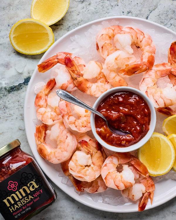 Platter of shrimp with harissa sauce on a gray surface. The Spice & Tea Shoppe