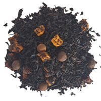 Black tea leaves with orange peel and nuts on a white background_ Caramel Spiced Rum Black Holiday Tea_ The Spice & Tea Shoppe