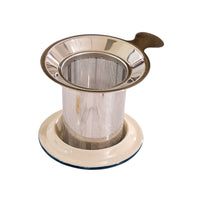 Metal tea strainer on a white marble surface