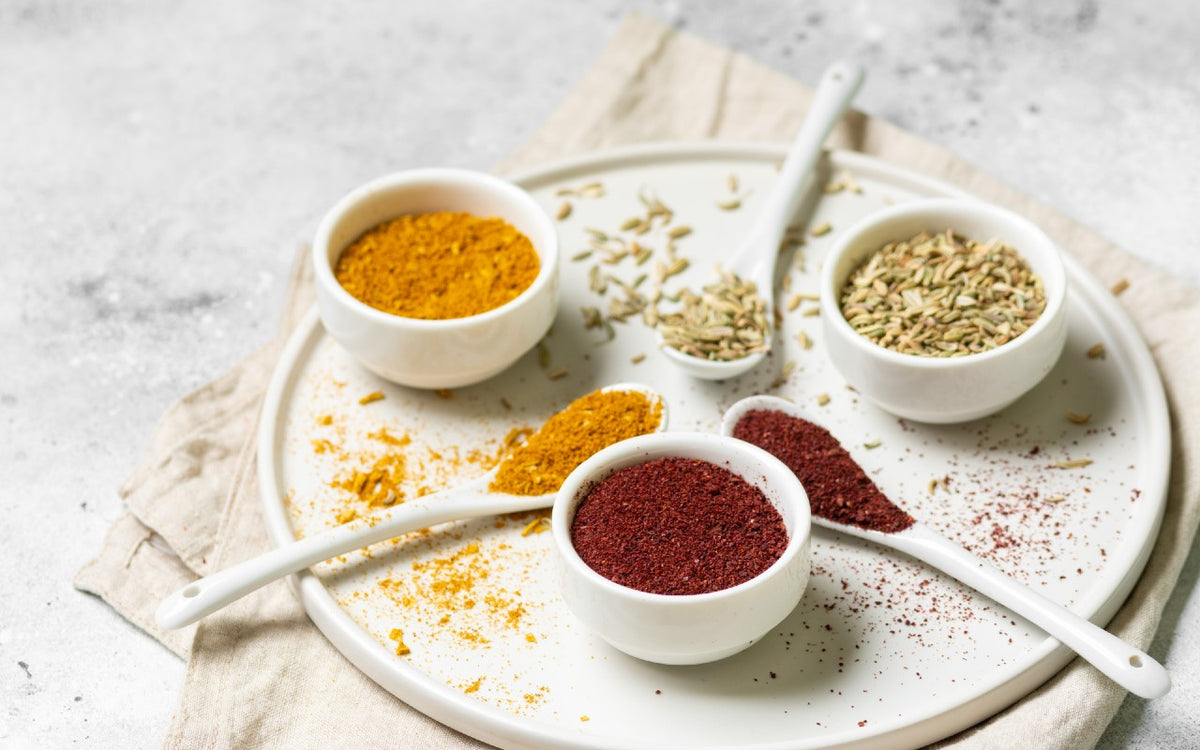 Vibrant assortment of aromatic spices arranged neatly on a plate. The Spice and Tea Shoppe